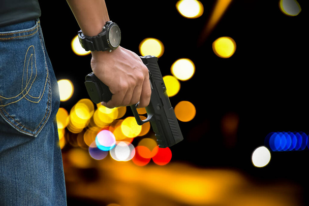 Pistola automática negra de 9 mm con las manos listas para disparar, concepto de seguridad, robo, seguridad, guardia, gángster, mafia y deportes de tiro en todo el mundo. - Foto, imagen