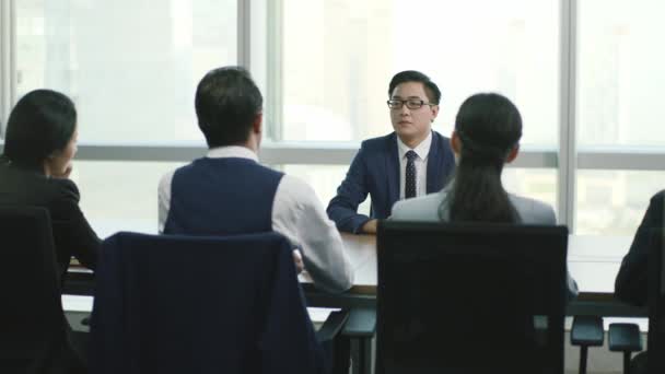 junger asiatischer Geschäftsmann wird von einer Gruppe von hr-Führungskräften interviewt - Filmmaterial, Video