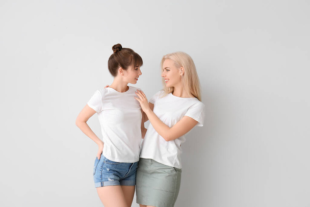 Joven pareja lesbiana sobre fondo gris - Foto, imagen