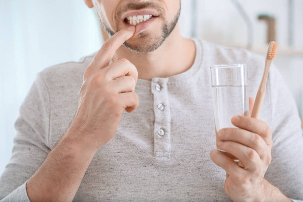 Man lijdt aan pijn tijdens het poetsen van tanden in de ochtend - Foto, afbeelding