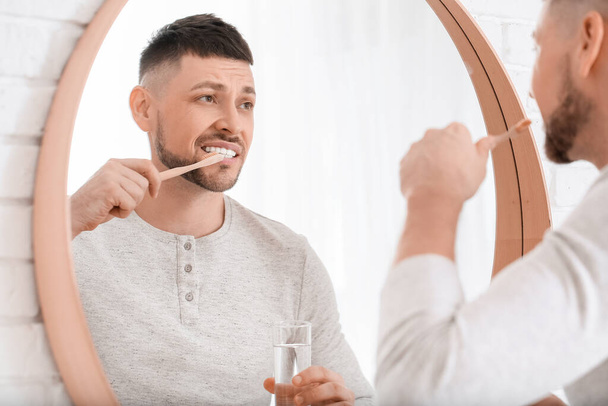 Man suffering from pain while brushing teeth in morning - Photo, Image