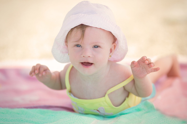 Vrolijke weinig meisje van de baby met Downs syndroom spelen in het zwembad - Foto, afbeelding