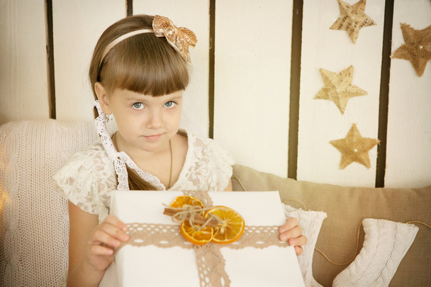 Mała dziewczynka otwiera prezent na Boże Narodzenie - Zdjęcie, obraz