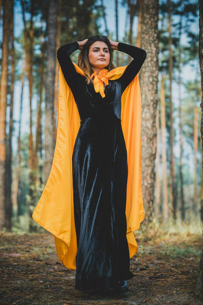 Mujer misteriosa con capa en el bosque. Ilustración a Halloween u otra historia de miedo - Foto, imagen