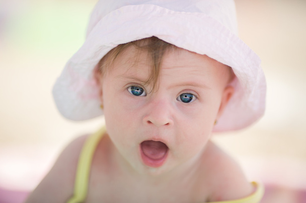 Iloinen pieni vauva tyttö Downs oireyhtymä pelaa altaassa
 - Valokuva, kuva