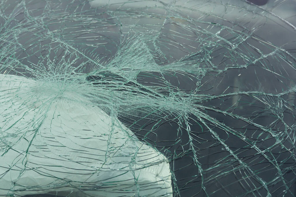 Arka planda hava yastığı olan bir arabanın ön camı ya da ön camı kırılmış. - Fotoğraf, Görsel