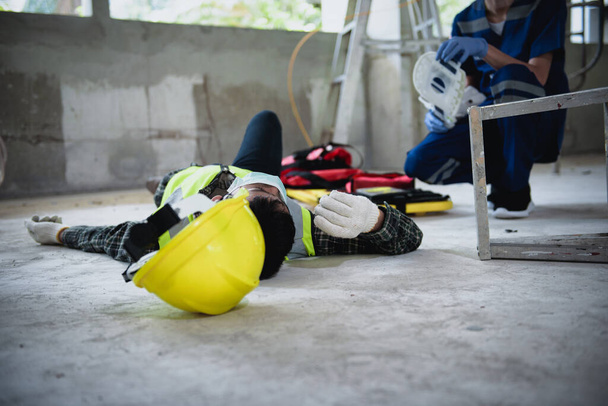 Work accidents of worker in the workplace at construction site area, Builder accident falls ladder on floor and Unconscious, Electric suction, Unsafe concept. - Photo, Image