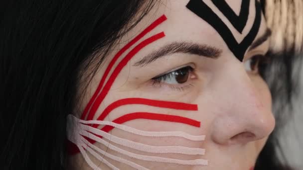 Mujer hermosa con cintas de kinesio en la frente y las mejillas contra las arrugas, cirugía estética lifting facial. Tratamiento kinesiológico de cerca - Metraje, vídeo