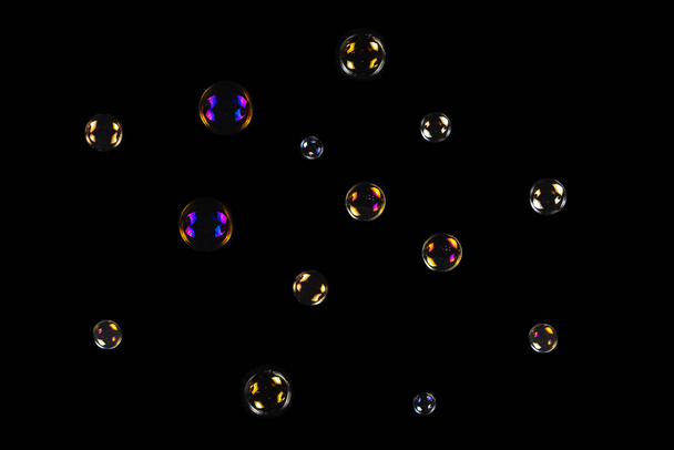 Мыльные пузыри изолированы на чёрном фоне. Копирование пространства.  - Фото, изображение