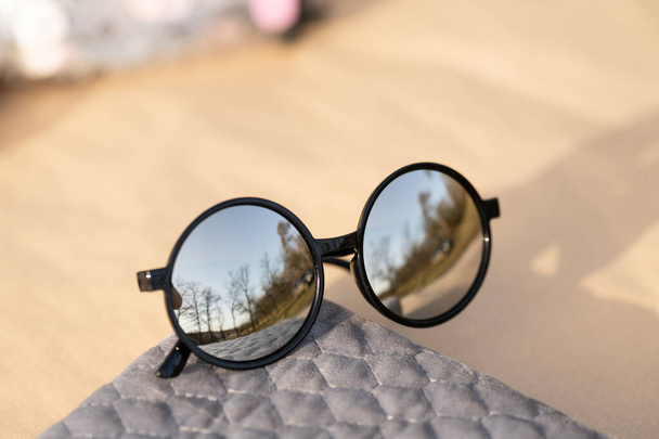 Gafas de sol con grandes lentes redondas plateadas que disparan al aire libre en un primer plano de día soleado. Enfoque selectivo - Foto, imagen