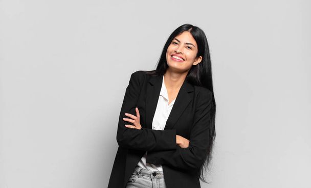 young hispanic businesswoman laughing happily with arms crossed, with a relaxed, positive and satisfied pose - Foto, Imagen