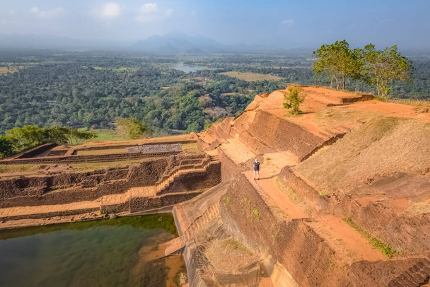 Osamělá blondýna běloška žena batohem turista navštíví terasovité zahrady na vrcholu starobylé historické Sigiriya Rock pevnosti nebo Lion Rock na Srí Lance. - Fotografie, Obrázek