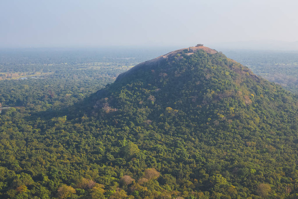 Krajinný pohled na kopec Pidurangala a okolní džungli z vrcholu skalní pevnosti Sigiriya na Srí Lance. - Fotografie, Obrázek