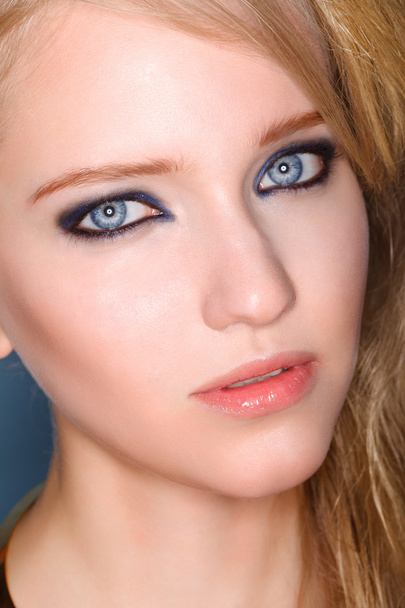 Portrait of young beautiful blond woman with smokey eyes - 写真・画像