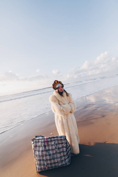 una joven con abrigo de piel y corona en la playa - Foto, imagen