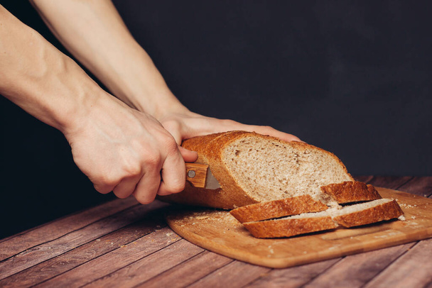 cutting a fresh loaf on a cutting board crispy bread  - Photo, Image