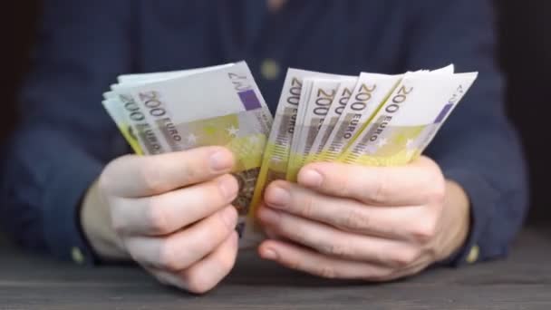 Κλείσιμο αντρικών χεριών που μετρούν χαρτονομίσματα του ευρώ - Πλάνα, βίντεο
