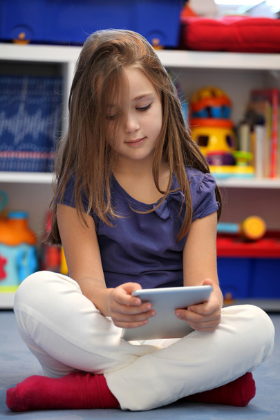 Menina pré-adolescente feliz usando um computador tablet digital
 - Foto, Imagem