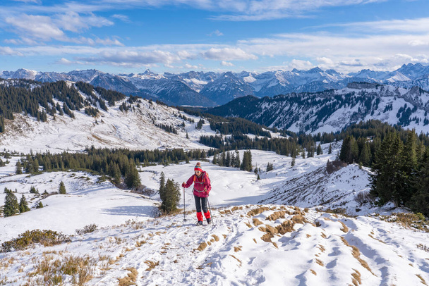 agradable y activa mujer senderismo de invierno en nieve en polvo en los Alpes de Allgau, Baviera, Alemania - Foto, imagen