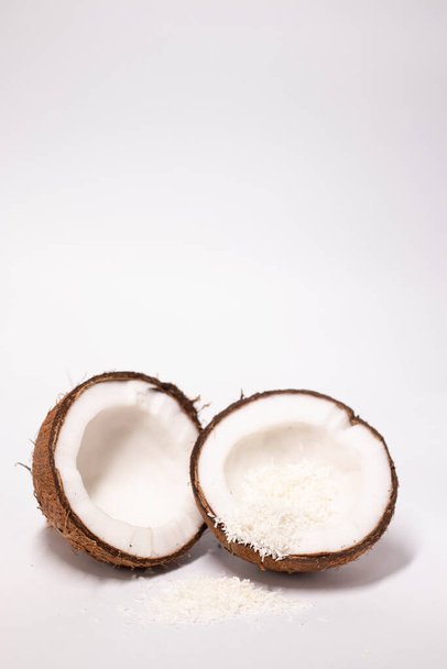otevřený kokos s kokosovými vločkami izolovanými na bílém pozadí. tropické, ořechové. - Fotografie, Obrázek