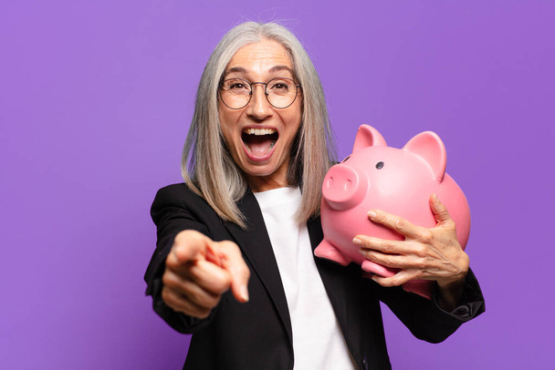 senior pretty businesswoman with a piggy bank - Фото, изображение