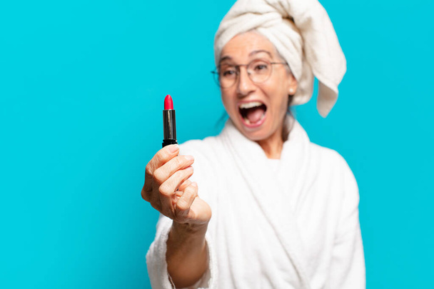 senior pretty woman after shower making up and wearing bathrobe - Фото, зображення