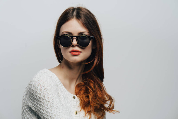привлекательная женщина в солнечных очках свободные волосы студия моды крупным планом - Фото, изображение