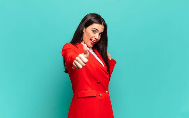 young pretty woman feeling proud, carefree, confident and happy, smiling positively with thumbs up. business concept - Foto, Imagem