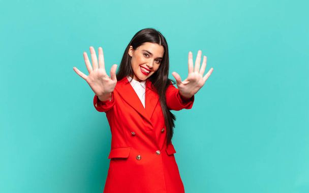 young pretty woman smiling and looking friendly, showing number ten or tenth with hand forward, counting down. business concept - Photo, Image