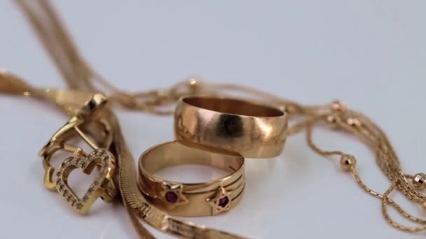 Χρυσά δαχτυλίδια, σκουλαρίκια και αλυσίδες περιστρέφονται γύρω από τον άξονά τους - Πλάνα, βίντεο