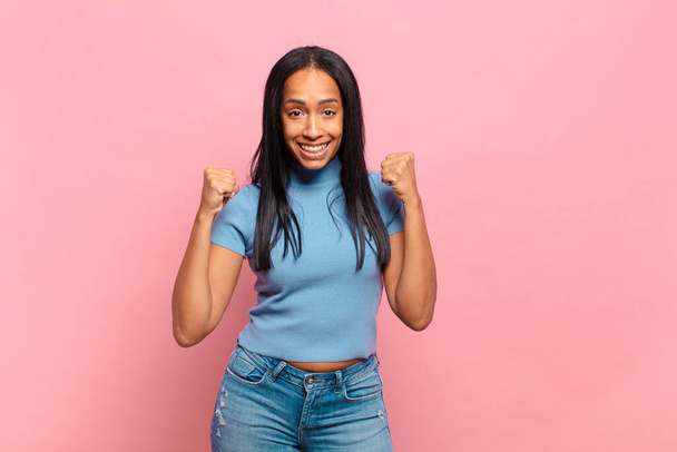 young black woman feeling shocked, excited and happy, laughing and celebrating success, saying wow! - Foto, Imagen