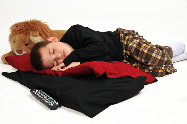 Giovane ragazzo su cuscini sul pavimento, addormentato guardando la televisione
 - Foto, immagini