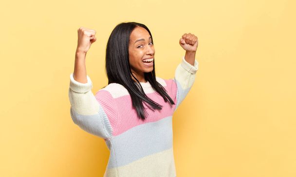 young black woman shouting triumphantly, looking like excited, happy and surprised winner, celebrating - Foto, Imagen