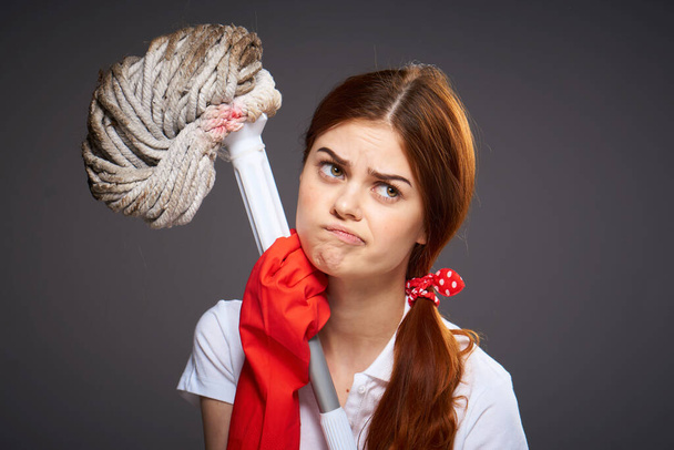 señora de la limpieza con expresión descontenta fregona en las habitaciones de limpieza de manos - Foto, Imagen