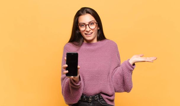 young pretty woman feeling happy, surprised and cheerful, smiling with positive attitude, realizing a solution or idea. phone screen concept - Photo, Image