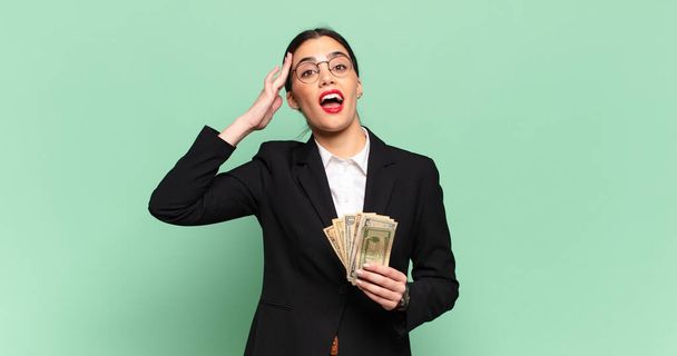 young pretty woman looking happy, astonished and surprised, smiling and realizing amazing and incredible good news. business and banknotes concept - Photo, image