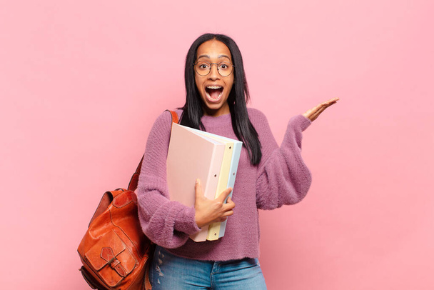 young black woman feeling happy, excited, surprised or shocked, smiling and astonished at something unbelievable. student concept - Foto, afbeelding