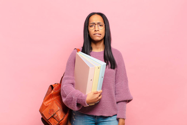 young black woman looking puzzled and confused, biting lip with a nervous gesture, not knowing the answer to the problem. student concept - Foto, Bild