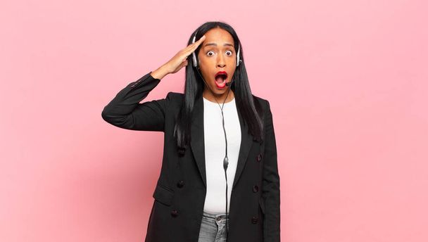 young black woman looking happy, astonished and surprised, smiling and realizing amazing and incredible good news. telemarketing concept - Foto, Imagem