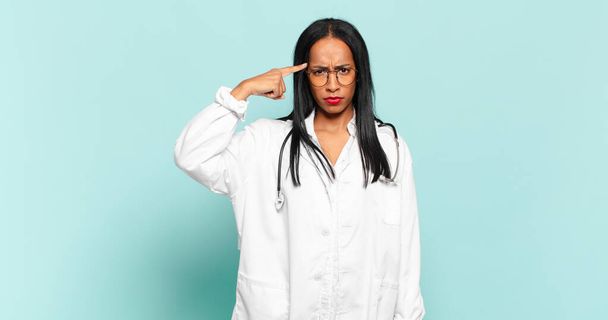 young black woman feeling confused and puzzled, showing you are insane, crazy or out of your mind. physician concept - Foto, Bild