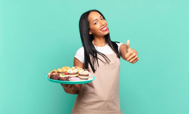 young black woman feeling proud, carefree, confident and happy, smiling positively with thumbs up. bakery chef concept - Valokuva, kuva