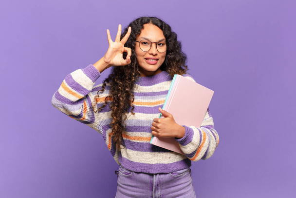 young hispanic woman feeling happy, relaxed and satisfied, showing approval with okay gesture, smiling. student concept - Fotoğraf, Görsel