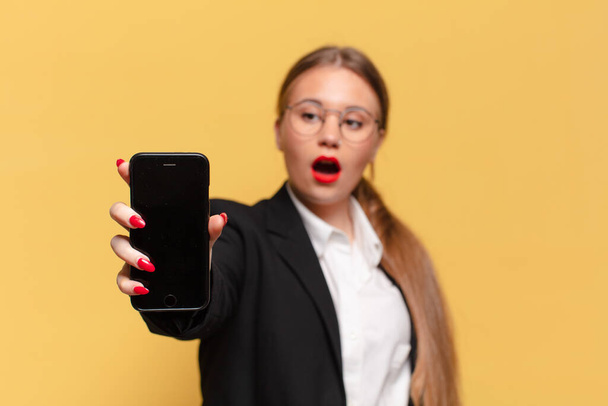 young pretty woman. shocked or surprised expression smart phone concept - Photo, image