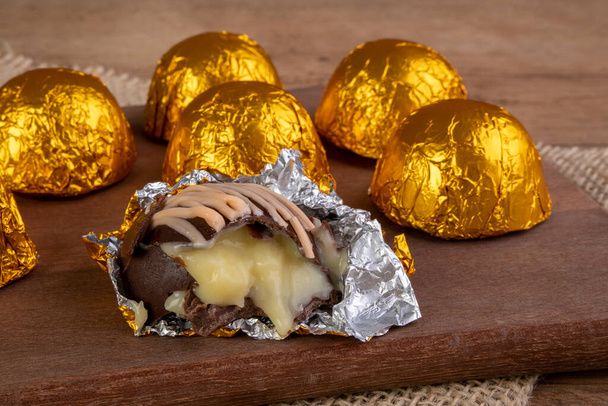 truffes au chocolat enveloppées dans du papier feuilleté sur planche à découper en bois - Photo, image