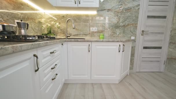 Szekrény billenő kamera mozgás a modern klasszikus fehér konyha belső - Felvétel, videó