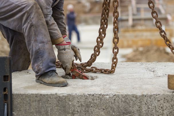 Rakennustyöntekijä valmistelee betoniprofiilia nosturin nostamiseen
 - Valokuva, kuva