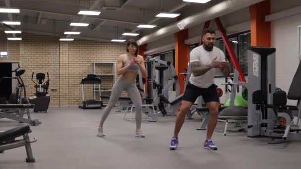 Sportovkyně trénink s osobním instruktorem v tělocvičně - Záběry, video
