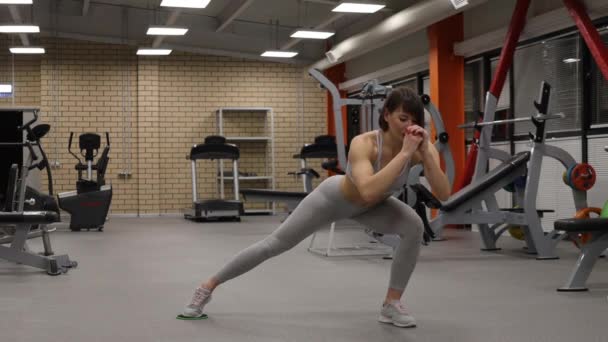 Mujer deportiva calentando y entrenando en el gimnasio - Metraje, vídeo
