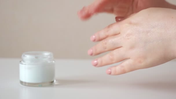 Femme méconnaissable frotte les mains avec de la crème, au ralenti - Séquence, vidéo