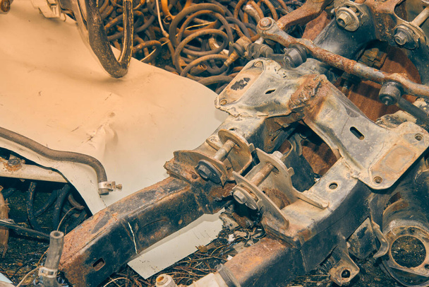 Altes Auto-Fahrgestell und Schraubenfeder sowie Kugelgelenksatz und Schlauch auf dem Boden. Abfallmaterial aus Garage im Vintage-Ton - Foto, Bild